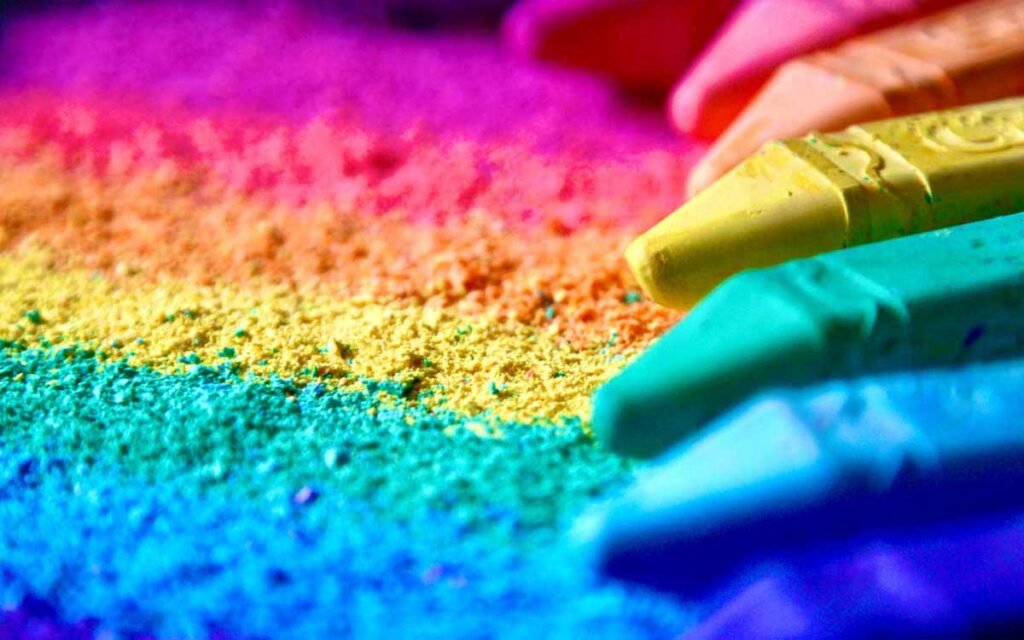 Crayola chalk scraping across the floor in rainbow colors